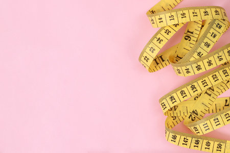 tape measure for obese people on a pink background soft focusの写真素材