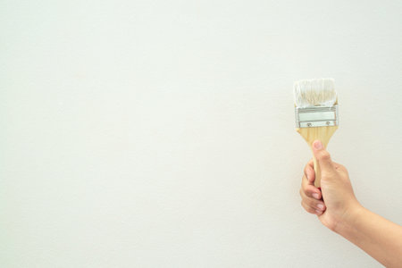 Roller Brush Painting, Worker painting on surface wall  Painting apartment, renovating with white color  paint. Leave empty copy space white to write descriptive text beside.の写真素材