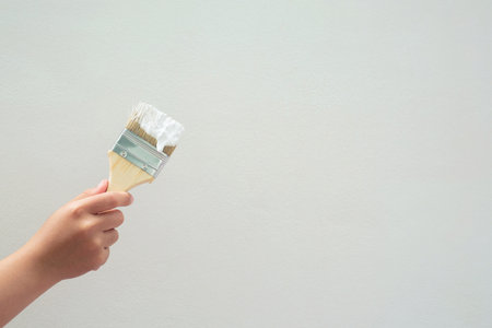 Brush Painting, Worker painting on surface wall  Painting apartment, renovating with white color ...