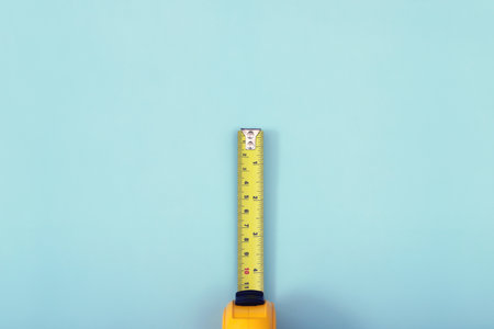 The yellow measuring tape for the mason is placed on a blue background. Soft focus.