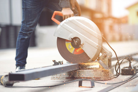 A worker cutting steel with a steel cutting machine sparked at a construction site.の写真素材