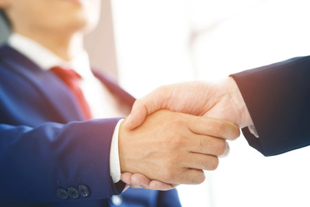 Closeup of a businessman hand shake businesswoman between two colleagues OK, succeed in business Holding hands.の写真素材