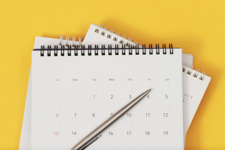 A pen with calendar on yellow backgroundの写真素材