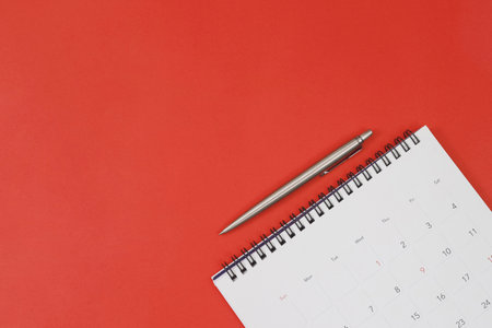 A pen with calendar on red backgroundの写真素材