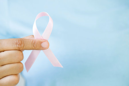 woman with Pink ribbon for patients with breast and cervical cancerの写真素材