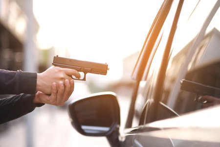 Thieves are using guns to rob a car, threatening a woman with car keysの写真素材
