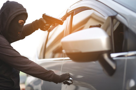 Thieves are using guns to rob a car, threatening a woman with car keysの写真素材