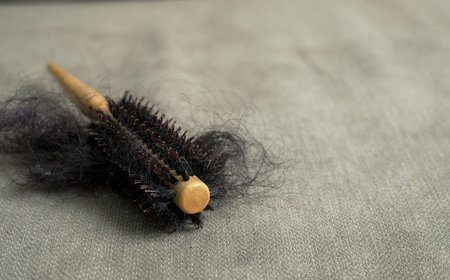 brush and damaged hair are placed on the sofa.の写真素材