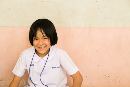 LOPBURI, THAILAND - FEBBRUARY 25, 2014 : Thai students sitting on the ground with smile on faces.のeditorial素材