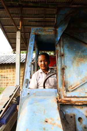 LOPBURI, THAILAND - FEBBRUARY 25, 2014 : Thai students sitting on old car