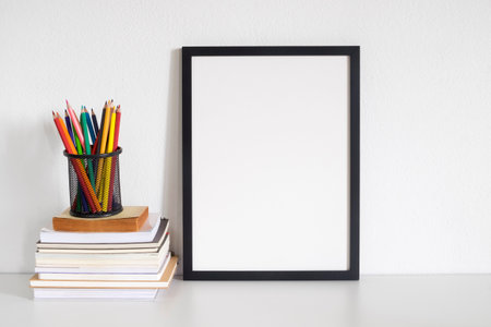 blank frame poster with book on deskの写真素材