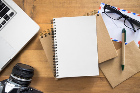 blank notepad with laptop,camera.envelope,pen eyeglasses on desk.checklist or plan travelerの写真素材