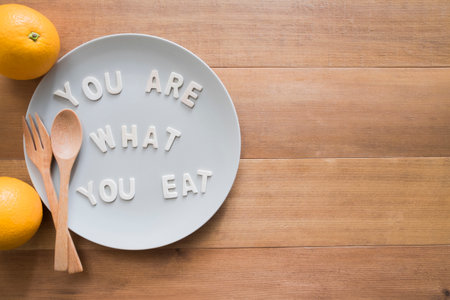 health care concept.orange fruit with quote "you are what you eat" and spoon.の写真素材