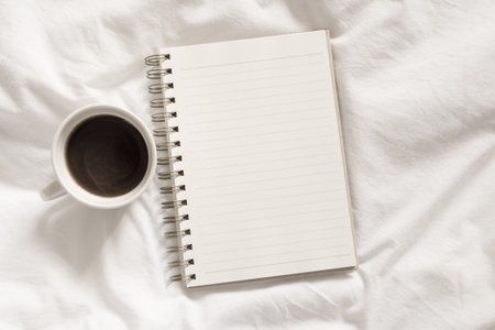 open diary with a cup of coffee on bedの写真素材