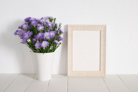 white frame with violet flower on table.の写真素材