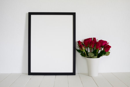 frame photo with red roses on wooden tableの写真素材