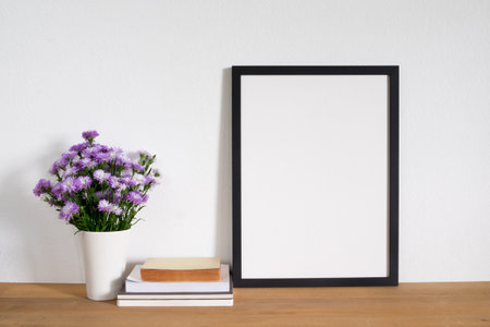 mock up frame photo with book and flower in vase on deskの写真素材