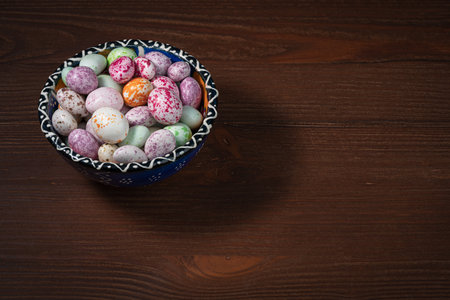 A blue cup with a pattern is filled with multi-colored sugar dragees.の写真素材