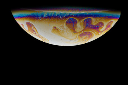 Imitation of an unknown planet. High resolution. Half a soap bubble. Close-up. Black background. Bright colors. Side view. The theme of science fiction.の写真素材
