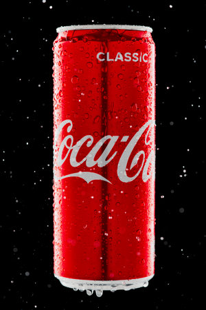 Russia, Republic of Bashkortostan, Mrakovo, - May 07, 2020: Coca-Cola aluminum can. Black background. Spray and drops of water. Side view. Close-up. Partly blurred.のeditorial素材
