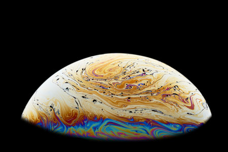 Half a soap bubble. Abstract pattern on the surface. Isolated on black background. Close-up.の写真素材