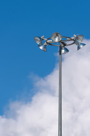 Street lighting. In the foreground is a tall lamppost with six lamps against the background of a...