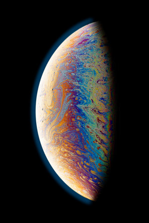 A black background with half of a soap bubble. Bright, colorful fantastic patterns.の写真素材