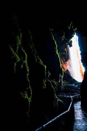 Interior of a huge cave hidden behind a large waterfallの写真素材