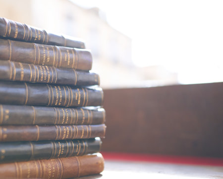 Brihuega, Spain 11-13-2020 Several old and slightly worn books stacked in a tower on a desk in an antique shopのeditorial素材