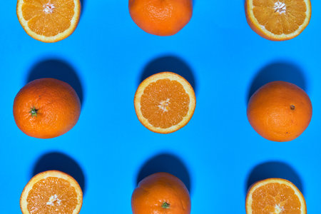 Whole and split oranges on a blue background. CITRUS CITRICの写真素材