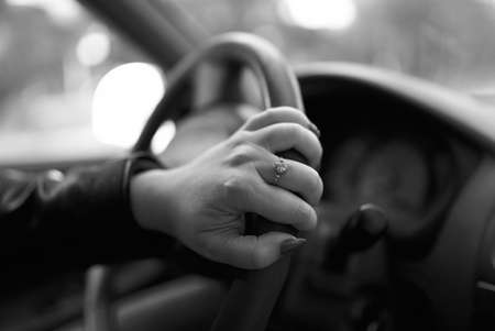Female hand holds the steering wheel while driving.の写真素材