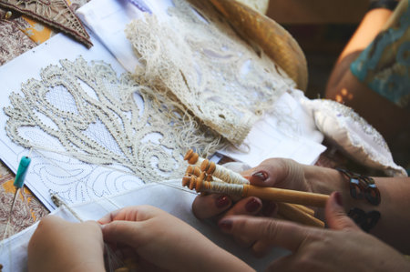 Close-up photo of a woman and a girl making lace using bobbinsの写真素材