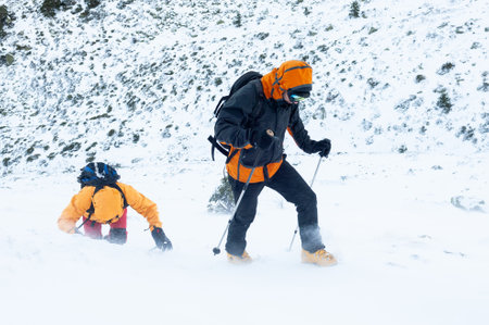 Snow hikers climbing a snowy mountain during a snowstorm in Cabezas de Hierro mountain in Spainの写真素材