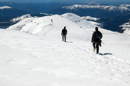 Snow hiker walking on a snowy hillside on a sunny day in Ordesa Natural Park, Pyrenees Spainの写真素材