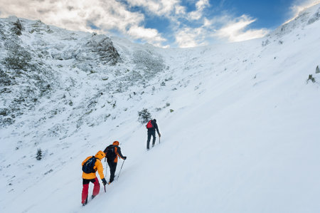 Snow hikers climbing a snowy mountain in a sunny day in Cabezas de Hierro mountain in Spain