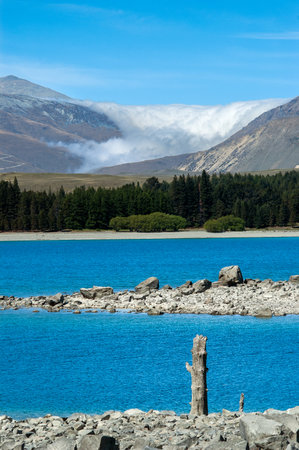 Takapo lake view in south island, new zealand with mountains and sea of clouds in the backgroundの写真素材