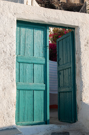 turquoise door in a typical mediterranean white house in santoriniの写真素材
