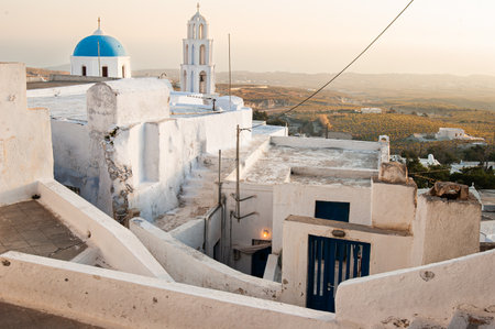 typical white church with blue dome in santorini island, greeceの写真素材