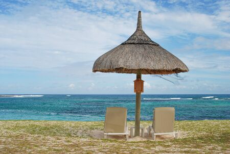 Umbrella and sun lounge chairs on tropical exotic beach in Mauritiusの写真素材