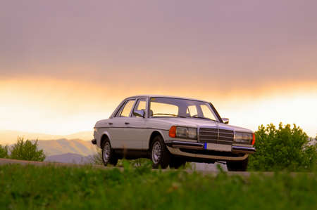 CLUJ-NAPOCA, ROMANIA - August 5, 2011: Illustrative editorial - Classic Mercedes-Benz W 123 white sedan car outdoor in nature at sunsetのeditorial素材