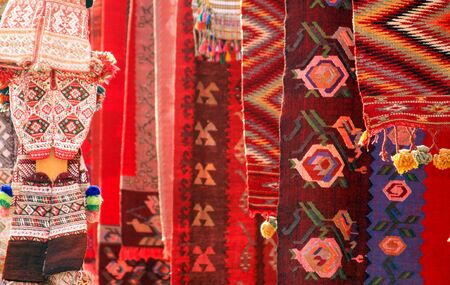 Red carpets and clothing souvenirs in Skopje, Macedonia. Detail view of textile patterns and texture in traditional market in the capital.の写真素材