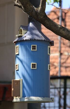 Blue bird house shaped like a miniature barn