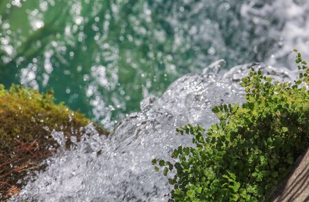 Detail of fresh clean water or creek flowing with vegetation. High exposure time splashes and dropsの写真素材