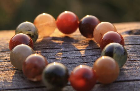 Bracelet jewelry made of different types of round gemstone beads, including translucent red, green, orange, yellow and white. Some of them are rutilated and tourmalinated quartz.の写真素材