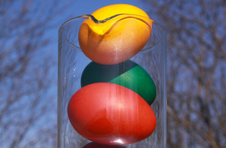 Colored painted Easter eggs in glass vase or carafe in preparation for holiday. Painting chicken or duck eggs is a Christian tradition to celebrate Easter all over the world.の写真素材