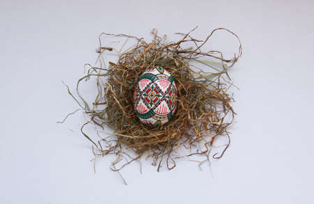 Isolated traditional handmade Easter eggs vintage decoration on hay. Seasonal motif on hand wax painting technique from Bucovina, Romania used to decorate Easter eggs in Moldova and Eastern Europe.の写真素材