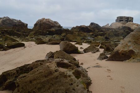 Set Of Rocks With A German Bunker At The Bottom Of The Atlanterra Beach In Zahara. Nature, Architecture, History, Street Photography. July 12, 2014. Zahara De Los Atunes, Cadiz, Spainのeditorial素材