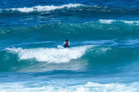 Long Haired Brunette Woman Catching Waves On Las Americas Beach. April 11, 2019. Santa Cruz De Tenerife Spain Africa. Travel Tourism Street Photography.の写真素材