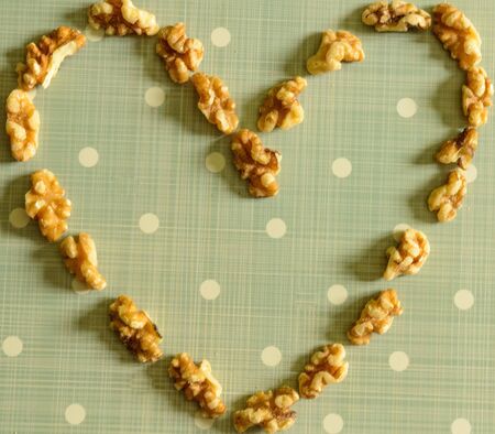 Peeled California Walnut Heart On Blue Background With White Dotsの写真素材