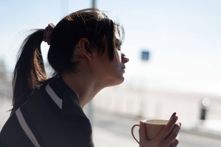 Woman drinking coffee in her campervanの写真素材